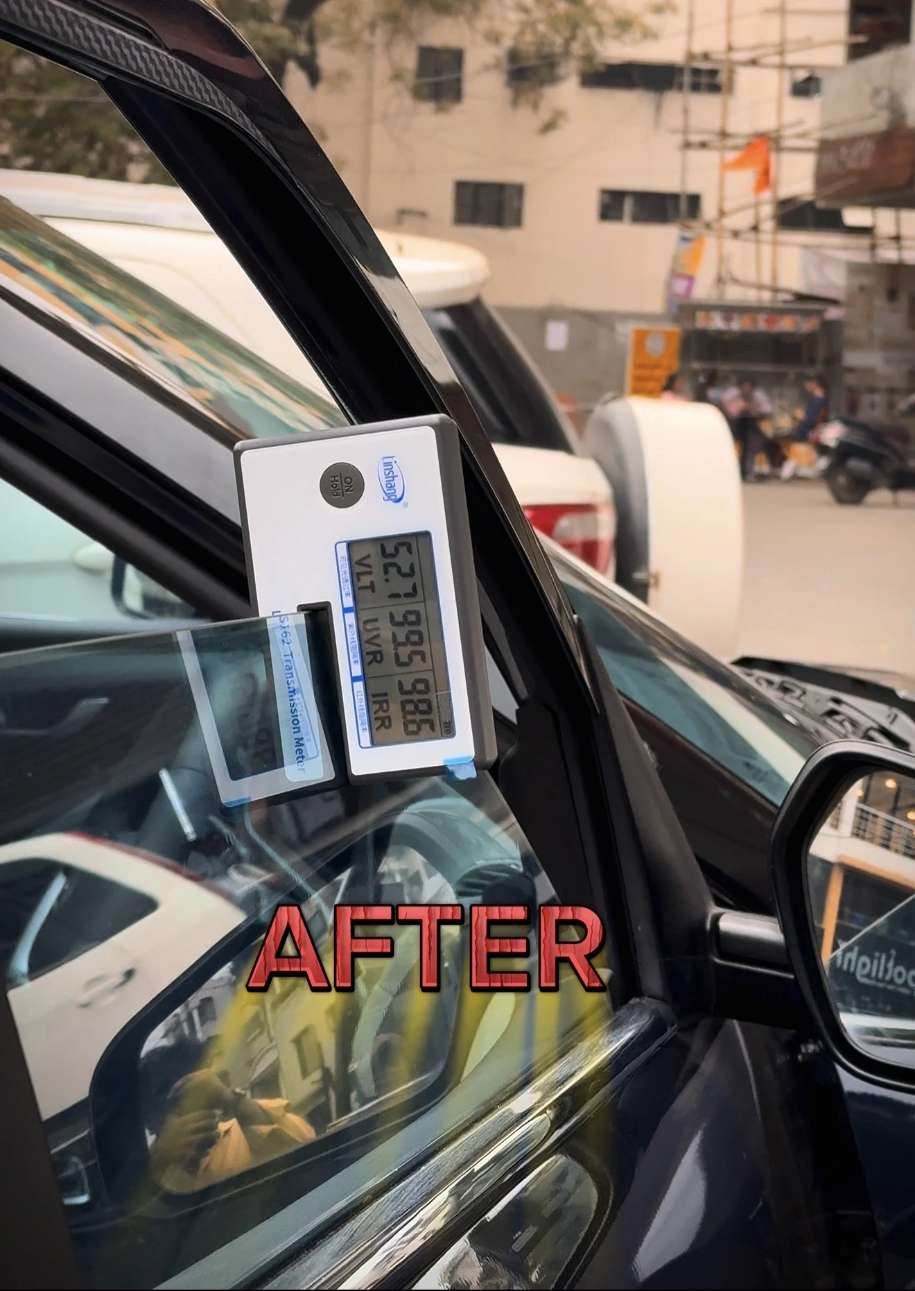 Linshang LS162 meter on a car's front side window after window film fitting, reading 52.7% VLT, 99.5% UV and 98.6% infrared rejection